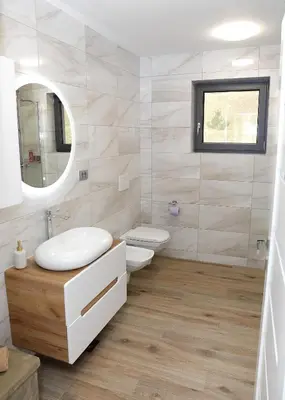 a bathroom with a sink and a toilet and a mirror at Apartma Belvi in Brežice