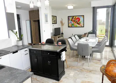 a kitchen and living room with a table and a dining room at Apartma Belvi in Brežice