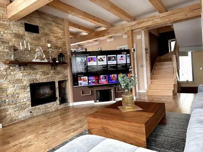 a living room with a fireplace and a tv at Luxury Panorama Villa • Pool, Quadro Sauna & Views
