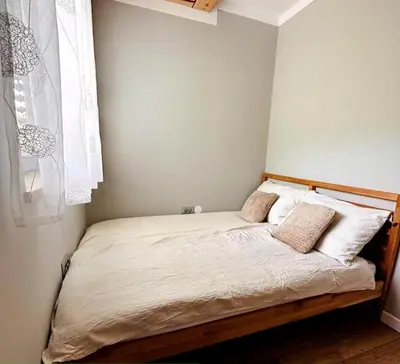 a small bedroom with a bed with white sheets and pillows at Luxury Panorama Villa • Pool, Quadro Sauna & Views
