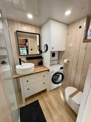 a bathroom with a sink and a washing machine at Secluded Romantic Cabin · Hot Tub & Barrel Sauna