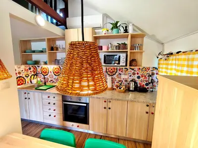 a kitchen with wooden cabinets and a large chandelier at Boho House 6 camp Terme Catez with promotional tickets prices in Čatež ob Savi
