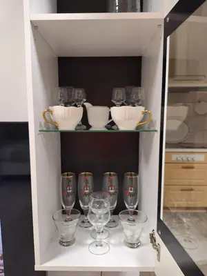a shelf with wine glasses and bowls on it at Apartment TINA in Kranjska Gora