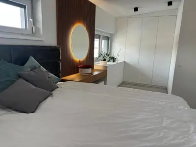 a bedroom with a large white bed and a mirror at Cosy house with sauna and jacuzzi in Miklavž na Dravskem Polju