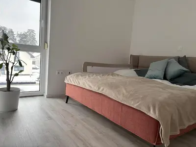 a bed in a room with a large window at Cosy house with sauna and jacuzzi in Miklavž na Dravskem Polju