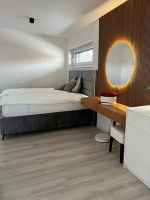 a bedroom with a bed and a desk and a mirror at Cosy house with sauna and jacuzzi in Miklavž na Dravskem Polju