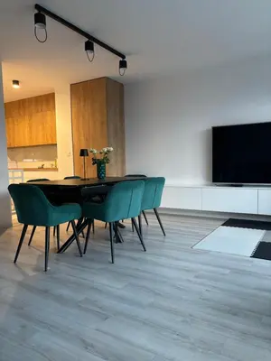 a dining room with a table and chairs and a tv at Cosy house with sauna and jacuzzi in Miklavž na Dravskem Polju