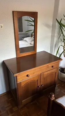 a wooden dresser with a mirror on top of it at Apartments Vila Ančka in Tržič