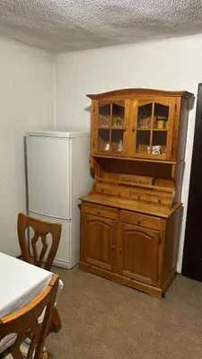 a kitchen with a wooden cabinet next to a refrigerator at Apartments Vila Ančka in Tržič