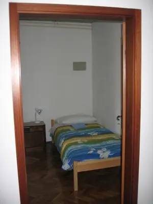 a small bedroom with a bed and a mirror at Guest House Rože in Ilirska Bistrica