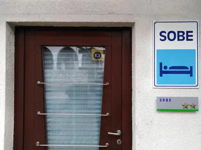 a door with a sign in front of it at Guest House Rože in Ilirska Bistrica