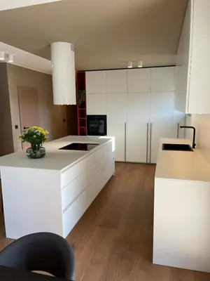 a kitchen with white cabinets and a vase of flowers at Lanina Estate in Spodnje Hoče