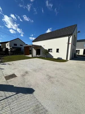 a white building with a black roof and a driveway at Lanina Estate in Spodnje Hoče