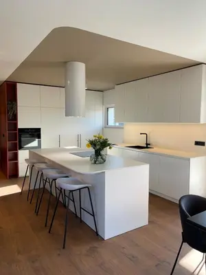 a kitchen with a large white island with bar stools at Lanina Estate in Spodnje Hoče