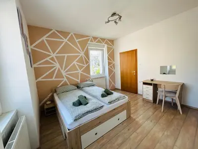 a bedroom with a bed and a desk at Spacious & Calm Guesthouse in Ljubljana in Ljubljana