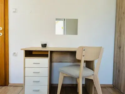 a wooden desk with a chair and a mirror at Spacious & Calm Guesthouse in Ljubljana in Ljubljana