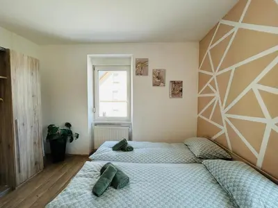 a bedroom with two twin beds and a window at Spacious & Calm Guesthouse in Ljubljana in Ljubljana