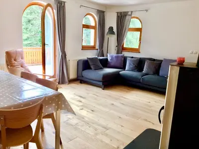 a living room with a couch and a table at Mountain View House - Panoramic! in Gozd Martuljek