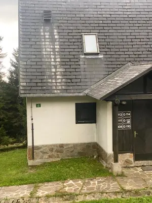 a house with a black roof and a door at Rogla Gaber Studio in Zreče