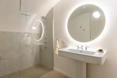 a white bathroom with a sink and a mirror at Valka in Ljubljana