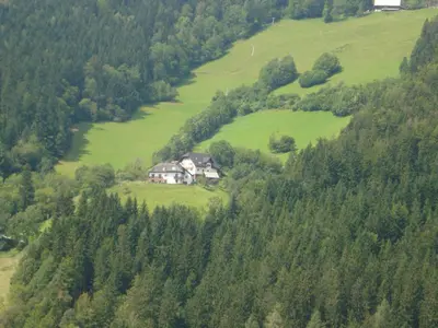 a house in the middle of a hill with trees at Farmstay Hiša Pečovnik in Luče