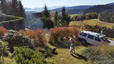 two people and a dog standing next to a vehicle at Holiday Home Tone in Frajhajm