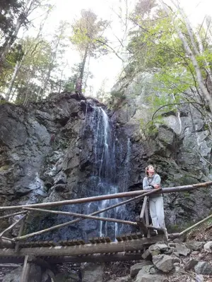 a woman standing on a bridge in front of a waterfall at Holiday Home Tone in Frajhajm