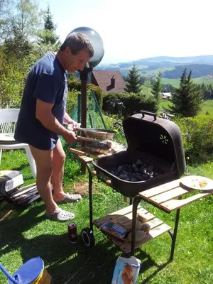 a man is cooking food on a grill at Holiday Home Tone in Frajhajm