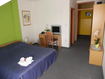 a bedroom with a bed and a desk with a computer at Motel Majolka in Ptuj