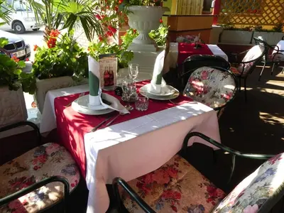 a table with a red table cloth and candles on it at Motel Majolka in Ptuj