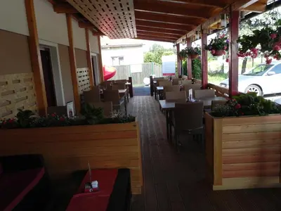 a restaurant with tables and chairs on a patio at Motel Majolka in Ptuj