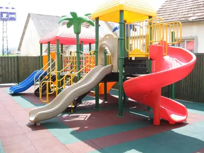 a playground with a slide in a park at Motel Majolka in Ptuj