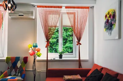 a living room with a red couch and a window at Apartment Tara in Ljubljana