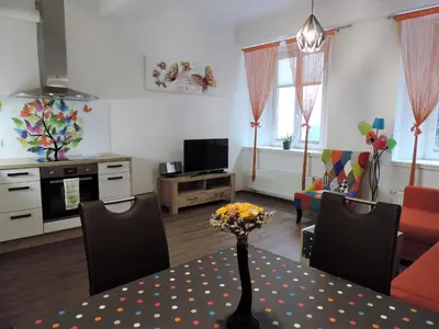 a living room with a table with a vase of flowers at Apartment Tara in Ljubljana