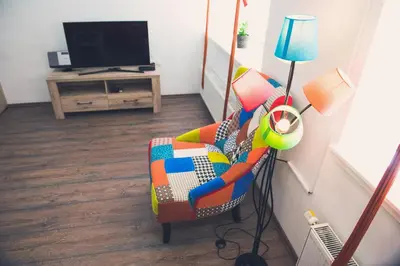 a living room with a chair and a television at Apartment Tara in Ljubljana
