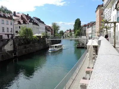 a boat traveling down a river in a city at Apartment Tara in Ljubljana