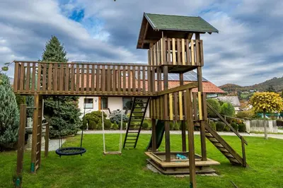 a wooden playground with a tree house at Zimzeleni Apartments in Zreče