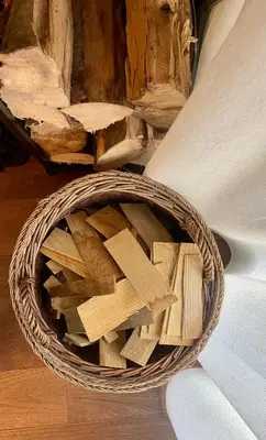 a basket filled with wood sitting on the floor at Ian's Residence in Kranjska Gora