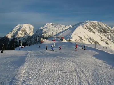 a group of people skiing down a snow covered mountain at Apartmajska hiša Muštrinka in Cerklje na Gorenjskem