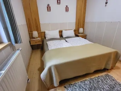 a small bedroom with two beds and a rug at Apartmajska hiša Muštrinka in Cerklje na Gorenjskem