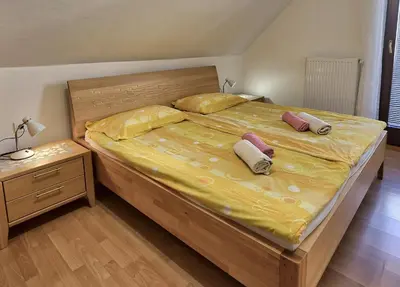 a bedroom with a large bed with two pillows on it at Apartmaji JOŠT in Bohinj