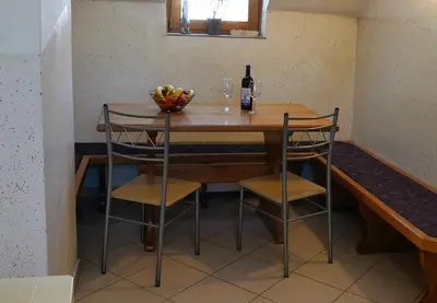 a table with a bowl of fruit and a bottle of wine at Apartmaji JOŠT in Bohinj