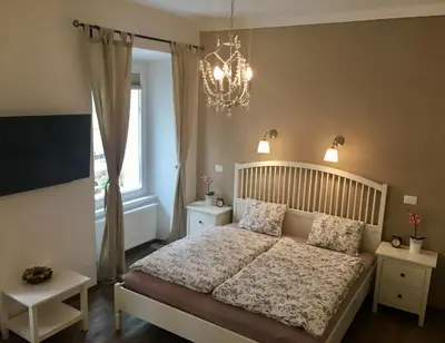 a bedroom with a bed with a chandelier and a window at Julija & Filip Apartments in Ljubljana