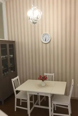 a dining room table with two chairs and a clock on the wall at Julija & Filip Apartments in Ljubljana