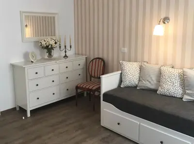 a bedroom with a white dresser and a bed and a chair at Julija & Filip Apartments in Ljubljana