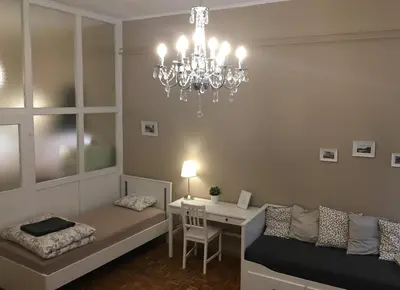 a living room with a chandelier and a desk at Julija & Filip Apartments in Ljubljana