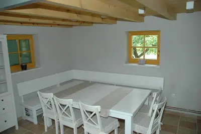 a dining room with a white table and chairs at Country house Martinova Klet in Prosenjakovci
