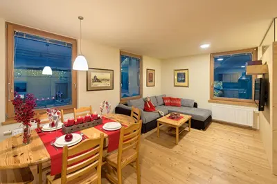 a living room with a table and a couch at Apartments Budinek in Kranjska Gora