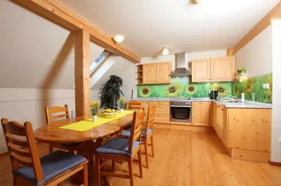 a kitchen with a wooden table and chairs at Apartments Budinek in Kranjska Gora