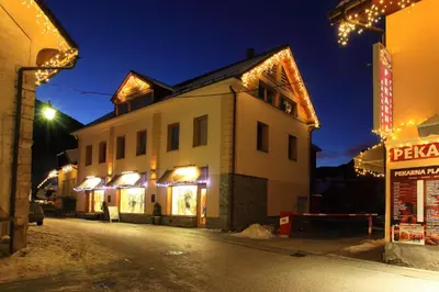 a building with christmas lights on a street at night at Apartments Budinek in Kranjska Gora